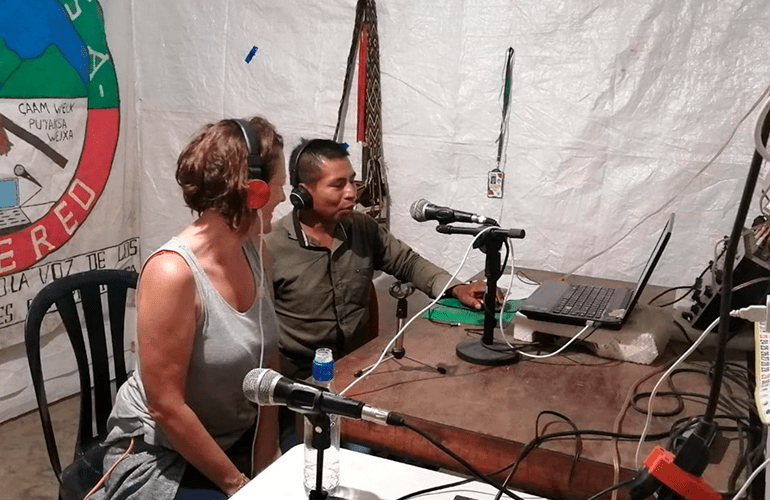 Miembro de la etnia Nasa hablando con turista para programa de radio en Tierradentro