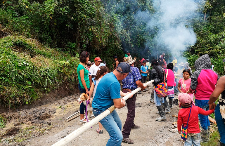 Visitantes y miembro de la etnia Nasa trabajando juntos en Tierradentro, Cauca