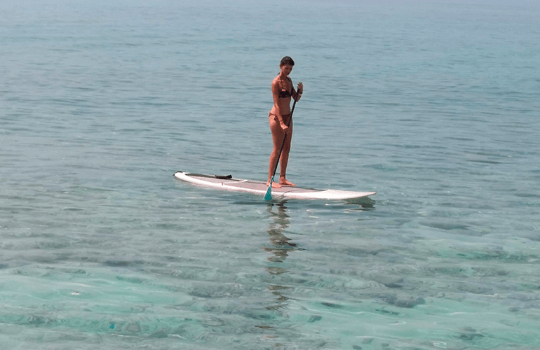 Mujer paddleboarding en el Mar Caribe