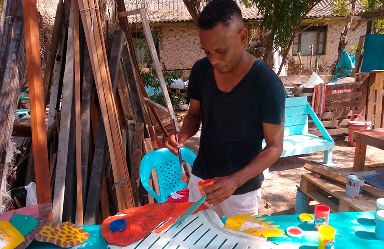 Hombre pintando coloridos accesorios en Islas del Rosario