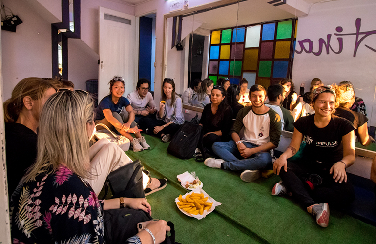 Bailarines y turistas compartiendo un refrigerio en la Academia de Unión Latina