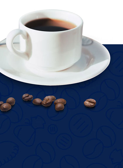 coffee cup on a plate next to coffee beans