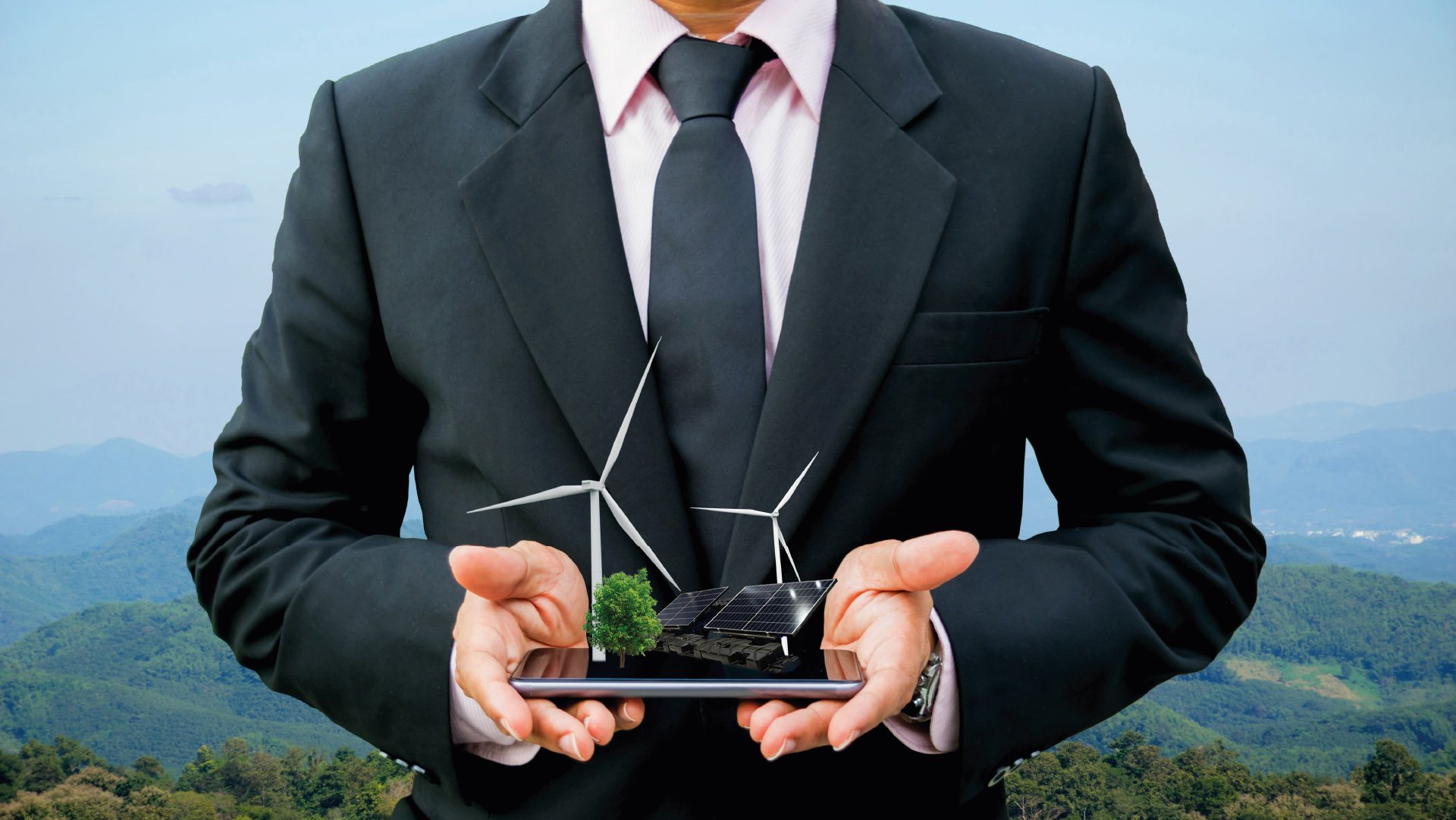 Hombre en traje sosteniendo un modelo conceptual de energías renovables.