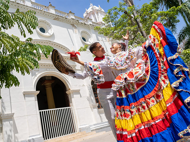 hombre y mujer con atuendos tradicionales de la cumbia bailando musica folclorica colombiana.
