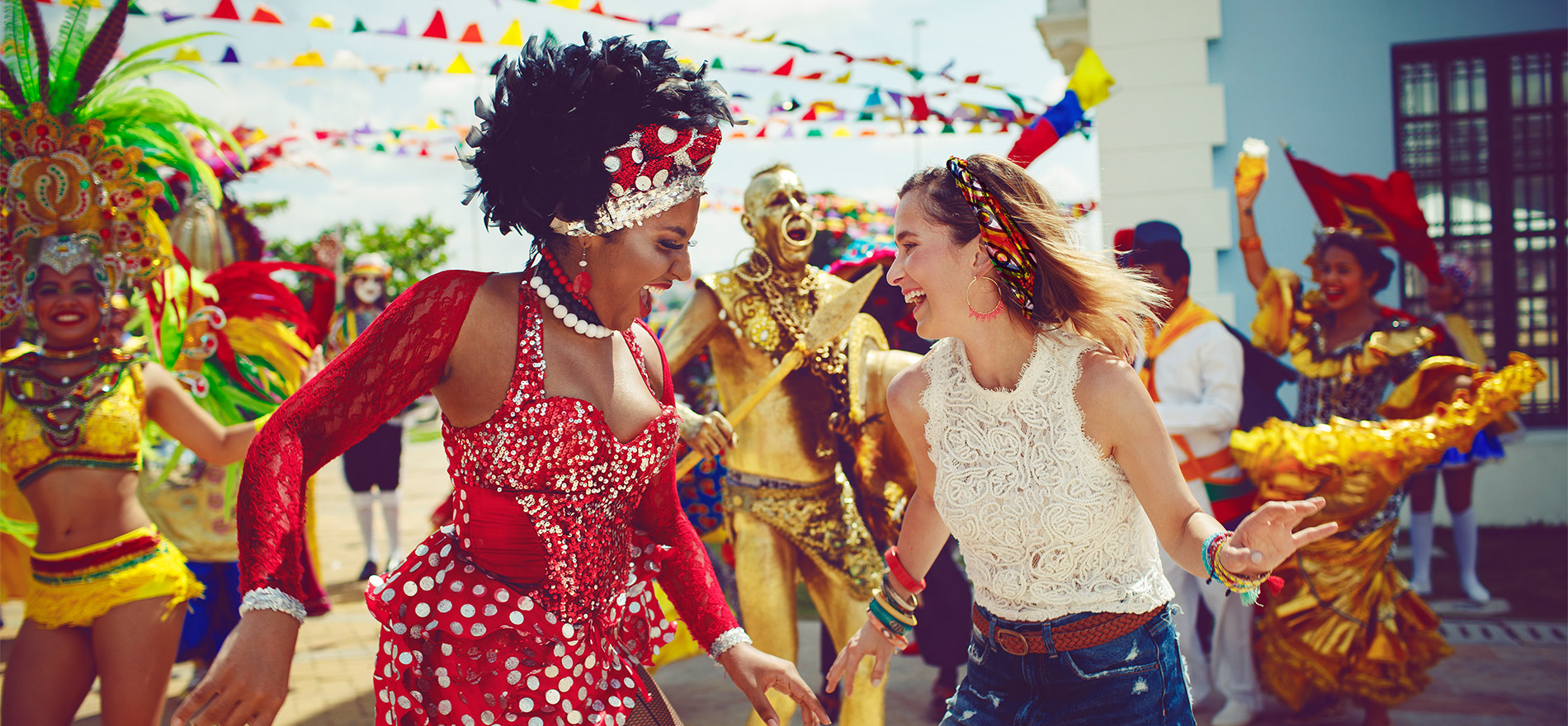 mujer afro y turista bailando en el carnaval de barranquilla con la musica en colombia.