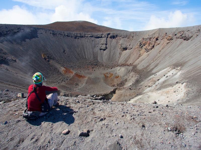 Vista de un hombre sentado en la cima de un cráter de un volcán extinto en San Agustín, Huila.
