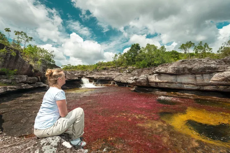 A woman admiring the beauty of Caño Cristales, a unique place in La Macarena