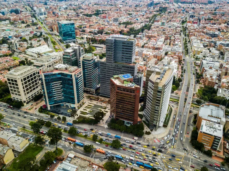 Vista aérea de la zona financiera de Bogotá con edificios modernos y denso tráfico.
