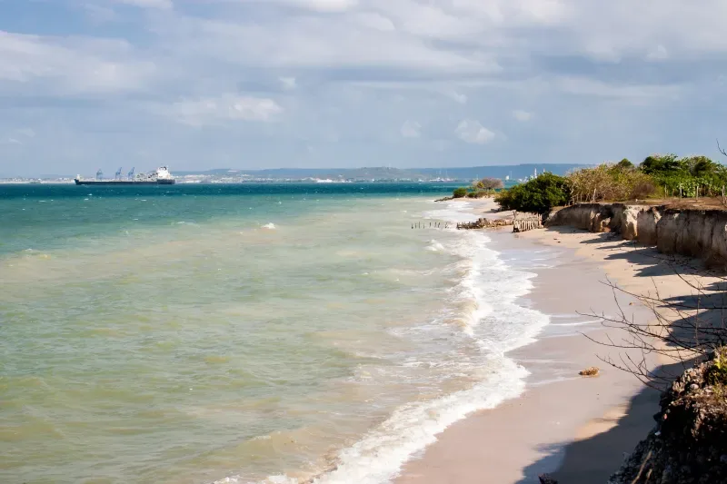 Beach, blue sky, blue sea, and boat on a sunny day at Tierra Bomba Island