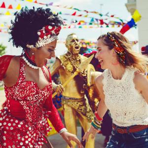 mujer afro y turista bailando en el carnaval de barranquilla con la musica en colombia.