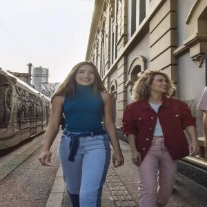 Tres turistas que caminan por la ruta del tranvía de Medellín, lugar ideal para hacer turismo alternativo.