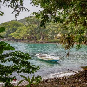 Vista de un bote blanco con azul desde las orillas del río Capurganá en Acandí.