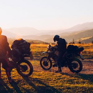 A couple takes a selfie on their motorcycle. Plan your route to enjoy the tourism offerings the country has.