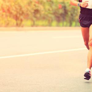 Two marathon runners running down a concrete road during a Triathlon training.