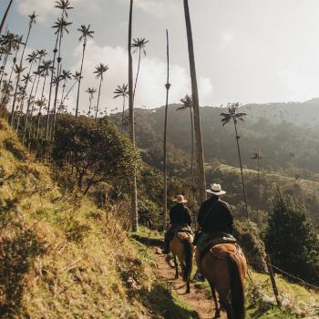 personas cabalgando en ruta del cafe colombiano en valle del cocora.