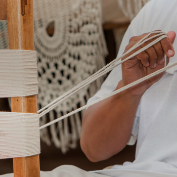 Un hombre teje una hamaca, uno de los tejidos artesanales más representativos de Colombia.