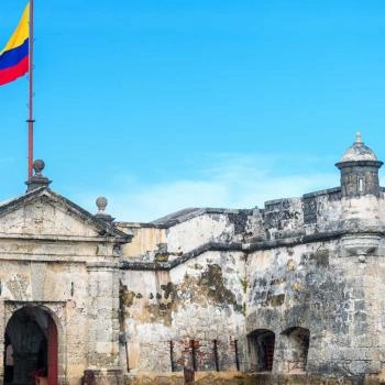 Walls of Cartagena with Colombia flag and blue sky